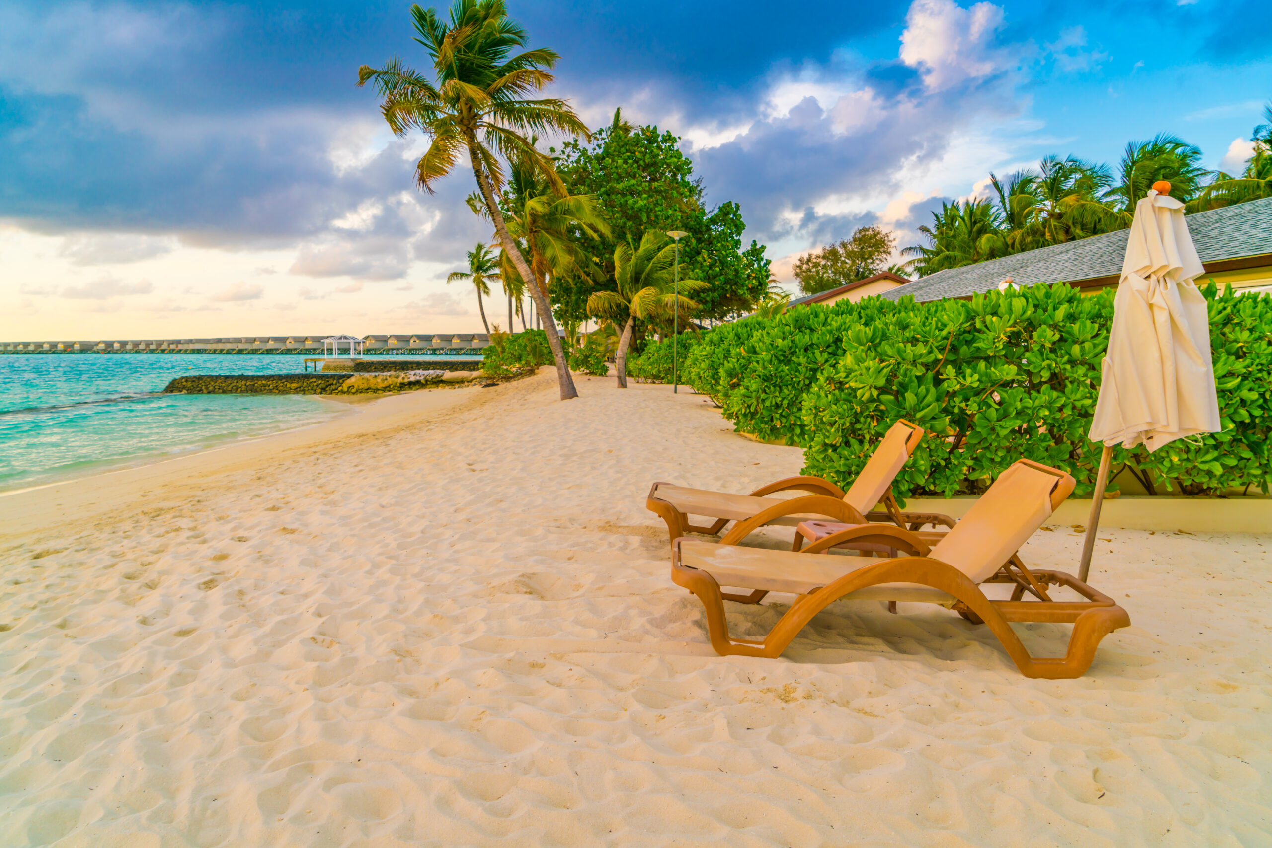 Beach chairs with umbrella at Maldives island, white sandy beach and sea